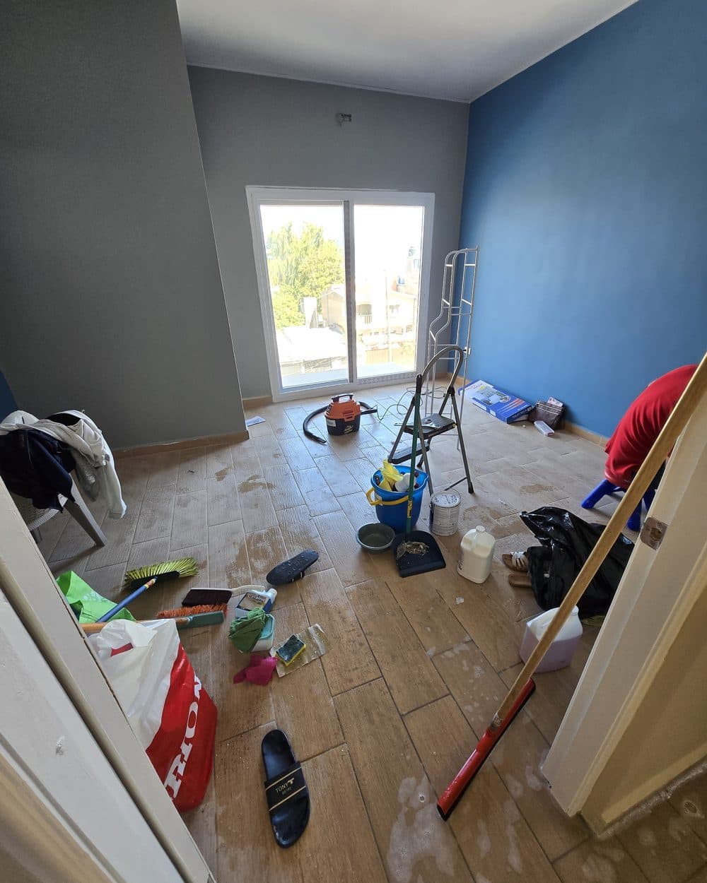 Cuarto de pared azul con restos de obra y, después, con el piso limpio — antes